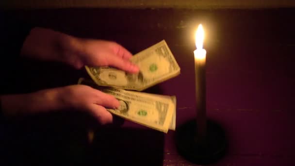 L'uomo conta banconote in dollari banconote in dollari a lume di candela al buio
 - Filmati, video