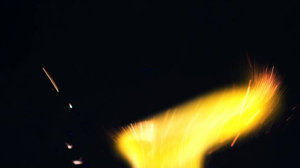 Foto Macro de los gatillos Bonfire. Bomberos estallidos, explosiones. Microgafas explosivas. Mini fuegos artificiales. Shooting on Red camera still on black background. Cartelera de chispa, banner, papel tapiz, textura. - Foto, Imagen