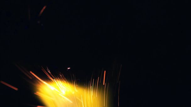 Macro photo of Bonfire sparks. Fire Flames bursts, blasts. Explosion micro sparkles. Mini Fireworks. Shooting on Red camera still on black background. Spark poster, banner, wallpaper, texture. - Фото, изображение