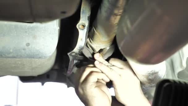 mechanik samochodowy naprawia samochód - Materiał filmowy, wideo