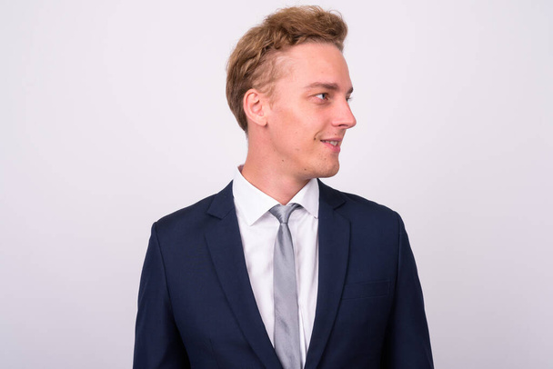 Studio shot of young handsome Scandinavian businessman with curly blond hair against white background - Photo, Image