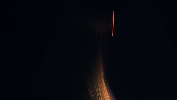 ボンファイアのマクロ写真が火花を散らします。炎が爆発し爆発する。爆発マイクロ輝きます。ミニ花火。まだ黒の背景に赤いカメラで撮影。スパークポスター,バナー,壁紙,テクスチャ. - 写真・画像