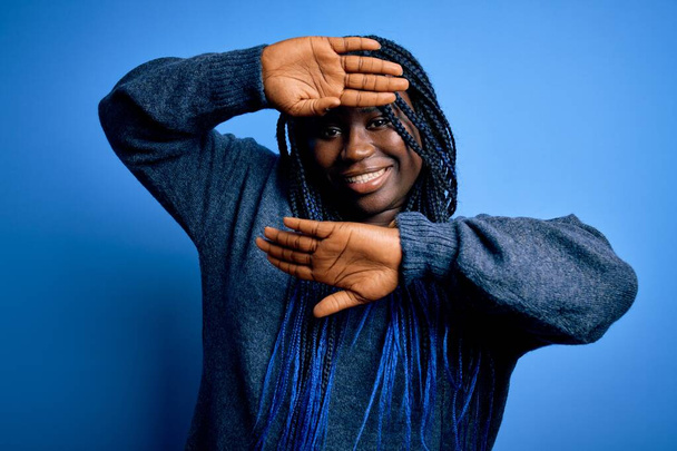 Afrikkalainen amerikkalainen plus koko nainen punokset yllään rento pusero sinisellä taustalla Hymyilevä iloinen pelaa kurkistaa boo kädet osoittavat kasvot. Yllätys ja poistuminen - Valokuva, kuva