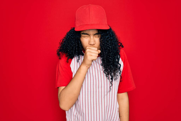 Young african american curly sportswoman wearing baseball cap and striped t-shirt feeling unwell and coughing as symptom for cold or bronchitis. Health care concept. - Foto, imagen
