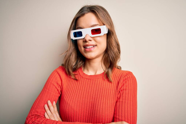 Young blonde girl wearing 3d cinema glasses over isolated background happy face smiling with crossed arms looking at the camera. Positive person. - Zdjęcie, obraz