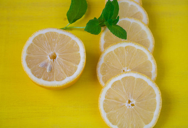 sliced lemon with mint leaves isolated on yellow - Photo, Image
