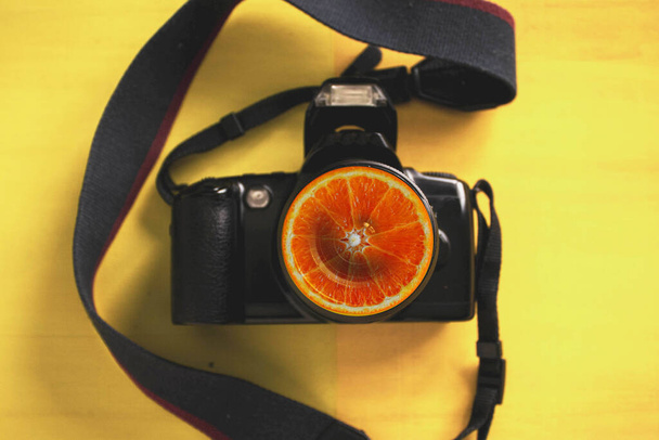 αντανακλαστικό κάμερας στην εστίαση που απομονώνεται σε μαύρο φόντο και πορτοκαλί - Φωτογραφία, εικόνα