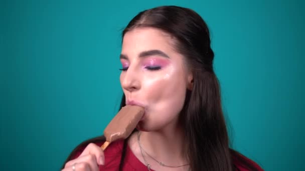 Ευτυχισμένη γυναίκα χαμογελά και τρώει γλείψιμο παγωτό σοκολάτα πορτρέτο κοντά - Πλάνα, βίντεο