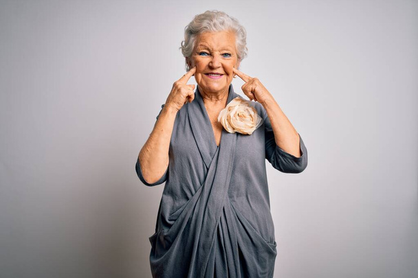 Senior beautiful grey-haired woman wearing casual dress standing over white background Smiling with open mouth, fingers pointing and forcing cheerful smile - Foto, afbeelding