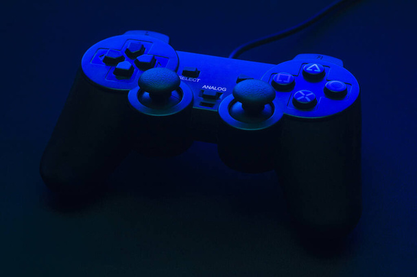 Gamepad negro con contraluz azul y hermosas sombras
. - Foto, imagen