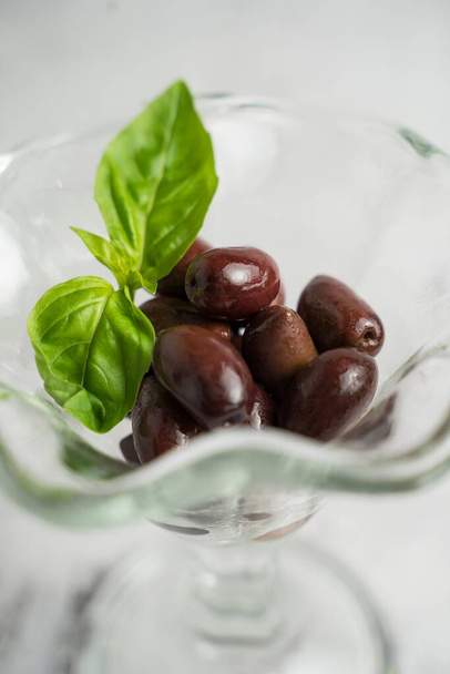 Maroon olives in a glass bowl - Photo, Image
