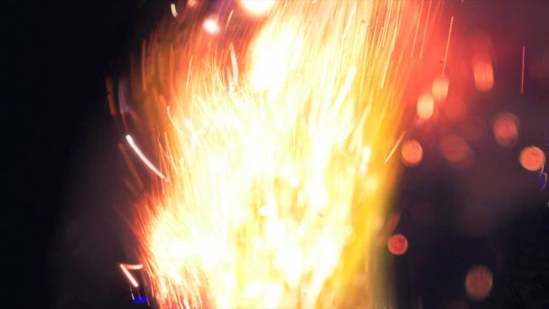 Makrofoto von Bonfire funks. Feuerflammen lodern, lodern. Explosionsartige Mikrofunkeln. Mini-Feuerwerk. Dreharbeiten auf roter Kamera noch auf schwarzem Hintergrund. Schöne Lecks Overlay Funke Poster, Banner, Tapete, Hintergrund, Textur. - Foto, Bild