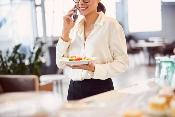 Joyful lady having phone conversation during lunch break - Φωτογραφία, εικόνα