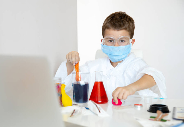 Smart little boy doing tests in home laboratory - Foto, afbeelding