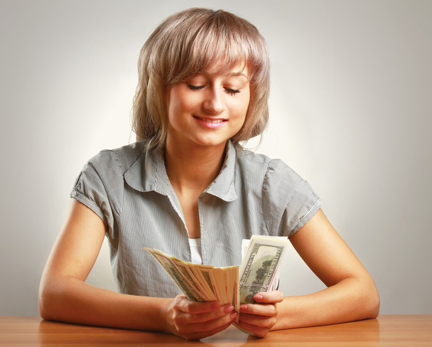 A young woman holding dollars - Фото, зображення