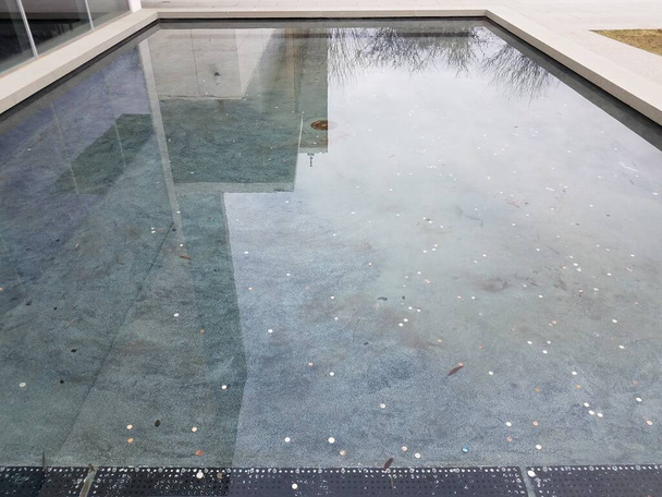 бассейн с водой с монетами и отражением зданий
 - Фото, изображение