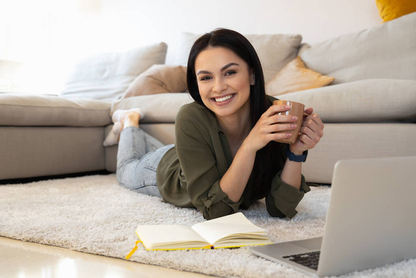 Radosna pani pije herbatę i korzysta z pracy online w domu - Zdjęcie, obraz
