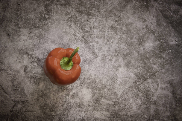 One Fresh Red Bell Pepper on a Black Cement Background - Valokuva, kuva