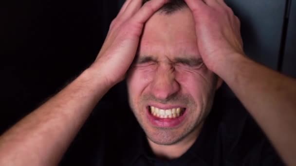 Close-up portret van de jongeman schreeuwen en schreeuwen van hoofdpijn en pijn. Lijden aan depressie en slecht humeur. Een gebroken man, boos en boos. Crisis en ongeluk. - Video