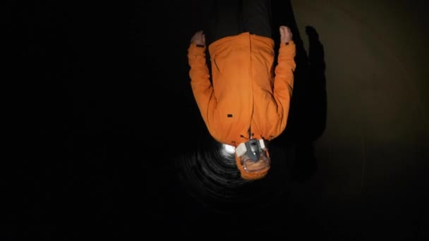 Een man loopt in een grote ijzeren pijp of een afgeronde schuilkelder in een beademingsapparaat. - Video
