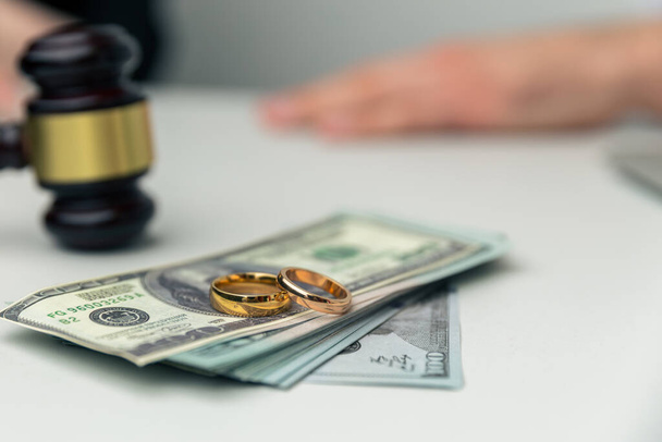 Divorce property. Money and wedding rings on the table. - Photo, Image