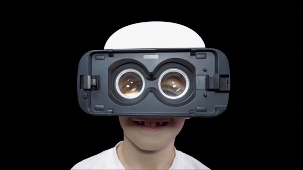 Vidám fiú virtuális valóság szemüvegben, hatalmas szemekkel. Mosolygó gyerek néz egy virtuális videót. Kiberpunk. Gömb alakú videó. Bővített Valóság. A fiú számítógépes játékokat játszik. Jövőbeli technológiák. - Felvétel, videó