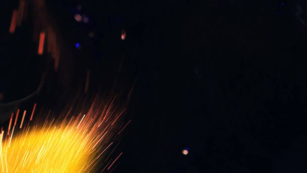 Macro photo of Bonfire sparks. Fire Flames bursts, blasts. Explosion micro sparkles. Mini Fireworks. Shooting on Red camera still on black background. Beautiful leaks overlay spark poster, banner, wallpaper, backdrop, texture. - Photo, Image