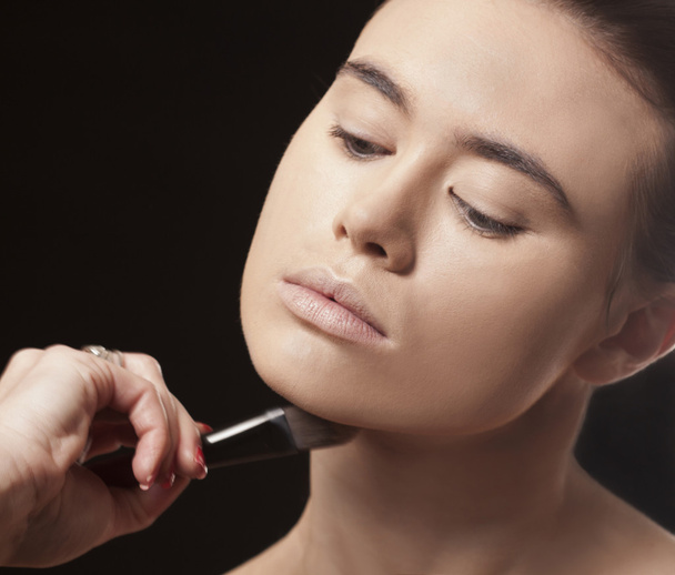 Hermosa mujer aplicando maquillaje con un cepillo
 - Foto, imagen