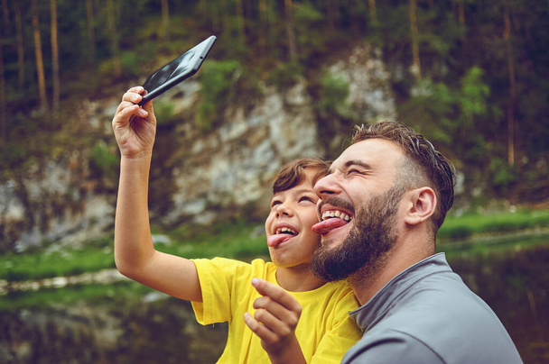 Eğleniyorum. Baba örneği asil insan. Oğlumla selfie çekiyoruz. Çocuk babasının omuzlarına biniyor. Çocuk babası olmanın mutluluğu.. - Fotoğraf, Görsel