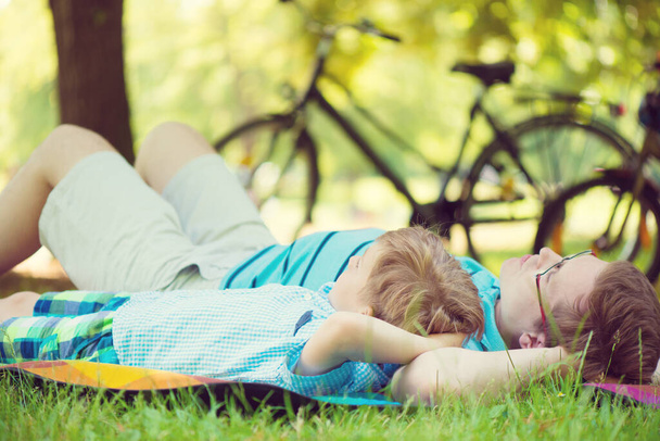 Joven padre con poco sol soñando en el parque de verano
 - Foto, Imagen