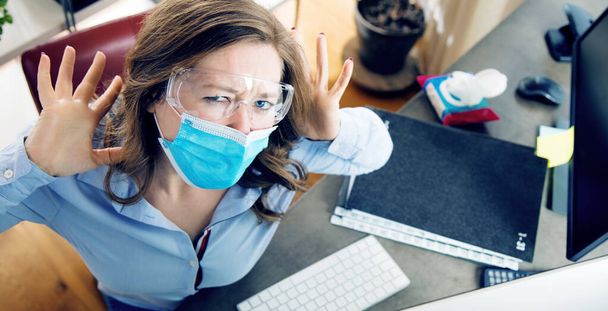 young woman in medical mask working from home during quarantine - Foto, Imagen