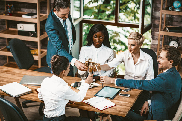 Разнообразная бизнес-команда выпивает шампанское в офисе
 - Фото, изображение