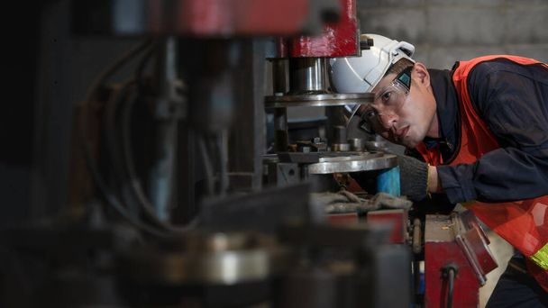 aziatische mannelijke machanische ingenieur supervisor controle en tuning boormachine in metwerk en deel productie fabriek - Foto, afbeelding