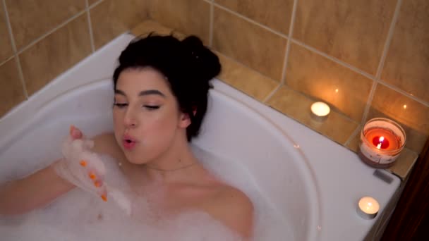 красива дівчина розслабляється на бульбашковій ванні, граючи з піною, затишною домашньою атмосферою
 - Кадри, відео