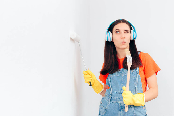 Funny Woman Painting the Wall Listening to Music with Headphones - Photo, Image