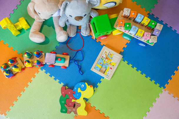 Veel verschillende speeltjes op puzzelspeelmatten in de slaapkamer - Foto, afbeelding