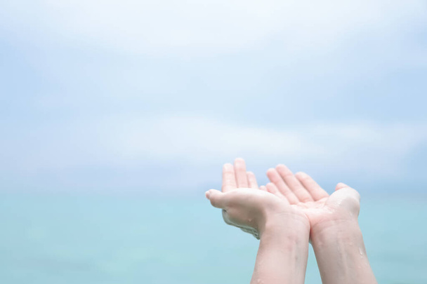 Donna mani posto insieme come pregare di fronte alla natura spiaggia pulita e sfondo cielo blu. - Foto, immagini