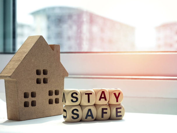 安全な概念を維持する。窓の近くの木造住宅で単語「安全滞在」,家に滞在, covid-19やコロナウイルスパンデミック予防のためのソーシャルメディアキャンペーン. - 写真・画像