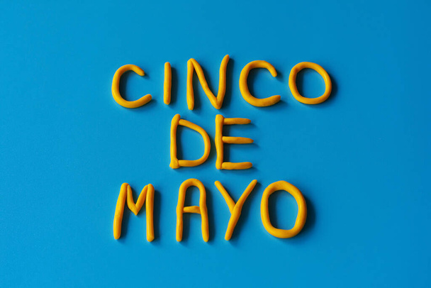 青地に粘土を敷き詰めた平地の上に「 CINCO DE MAYO 」という言葉がある。5月5日、アメリカ、メキシコの休日、テキスト付きの背景. - 写真・画像