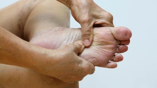 Mulher sênior que sofre de dor no pé esquerdo, Massageando pela mão em fundo branco, Close up & Macro shot, parte da pele do corpo asiático, Cuidados de saúde, Sobre o conceito de massagem
 - Filmagem, Vídeo