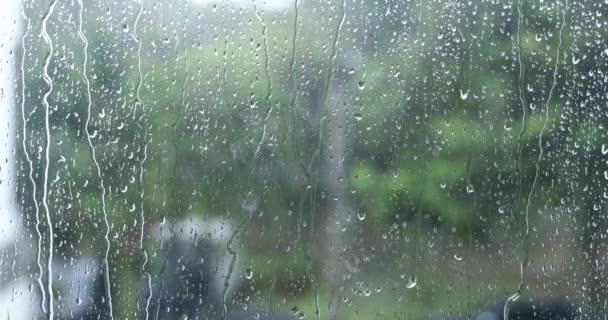 σταγόνες βροχής κοιτάζοντας μέσα από το γυαλί - Πλάνα, βίντεο