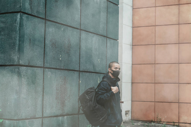 Muž, který má na sobě skutečnou masku proti znečištění, proti smogu a virům; hustý smog ve vzduchu a drží velké tašky. - Fotografie, Obrázek