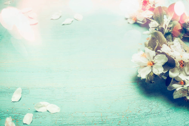 Bonita flor de primavera con iluminación bokeh sobre fondo de madera azul turquesa, vista superior, marco. Concepto de primavera
 - Foto, Imagen