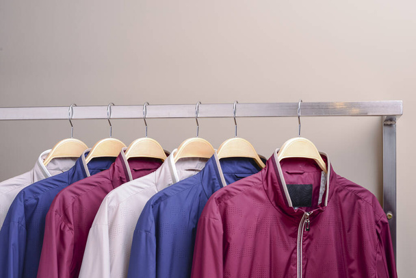 Riga di molte diverse giacche colorate con cappuccio, giacche sportive per uomini e donne. Abbigliamento stagionale in vendita
. - Foto, immagini