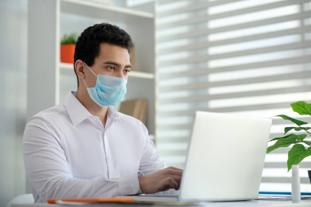 Man in a protective mask looking serious while working - Foto, immagini