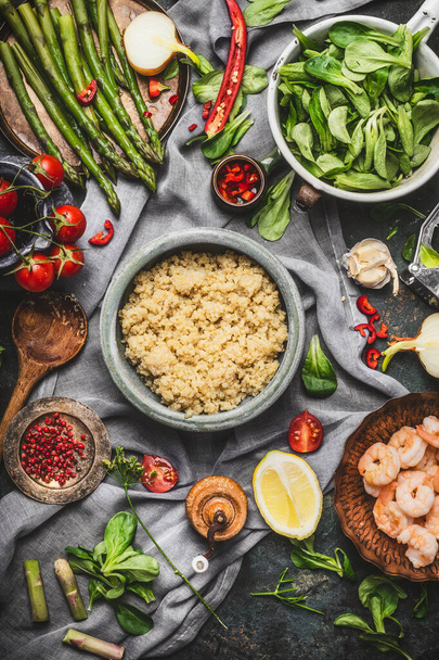 Top view of Healthy salad with asparagus and cooked quinoa seeds, preparation on rustic background with various organic vegetables. Vegetarian food and diet concept - Foto, imagen