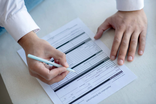 Close up of a man signing the unemployment application - Photo, Image