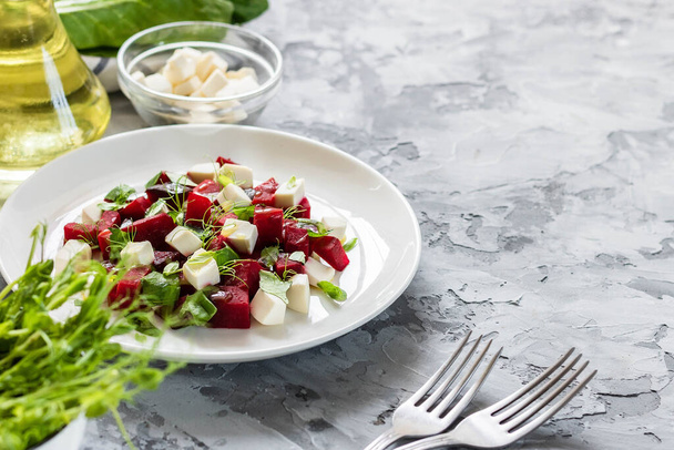Light spring and summer salad. Baked beets with feta cheese and shoots of young peas - Zdjęcie, obraz