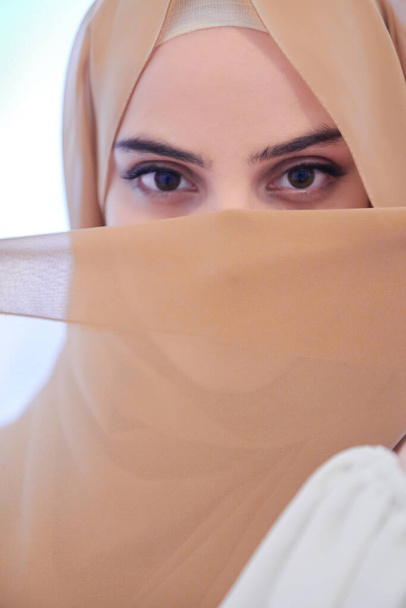 portrait of beautiful muslim woman in fashionable dress with hijab isolated on modern winter mountains background representing modern islam fashion and ramadan kareem concept - Valokuva, kuva