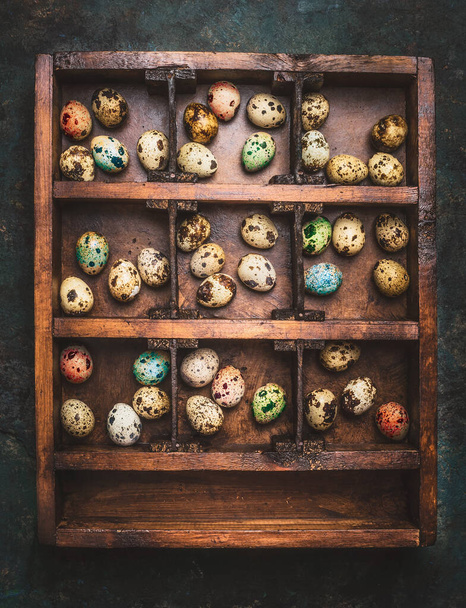 Vittage Wooden box with colorful eggs for Easter feast on dark rustic background, top view - Foto, imagen